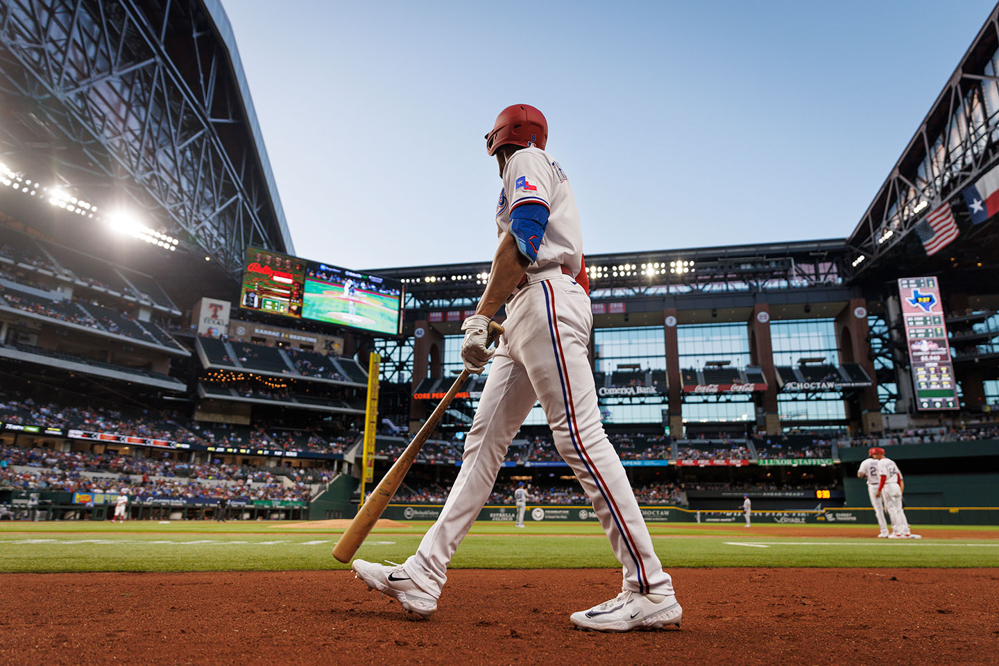 A Texas Ranger baseball player wearing a batting helmet and running on the baseball field.